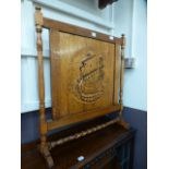 An early 20th century oak fire screen wi