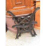 A pair of black painted metal bench ends