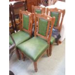 A set of four green upholstered dining c