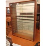 A teak glazed cabinet with glass shelvin