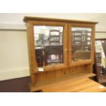 A pine framed mirrored two door cabinet