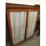 An oak glazed two door cabinet