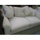 A large beige cut fabric three seat sett