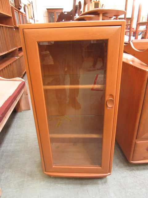 A light Ercol cabinet having a glazed do