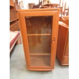 A light Ercol cabinet having a glazed do