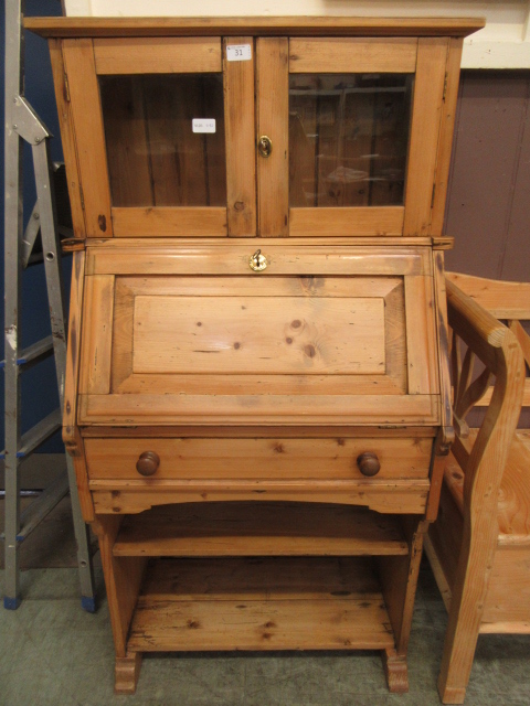 A waxed pine bookcase having a pair of g