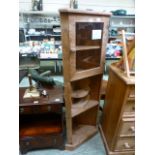 A waxed pine corner cabinet having a gla