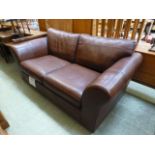 A modern brown leather two seater settee