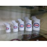 Five Esso oil cans