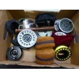 A box of assorted fishing reels and acce