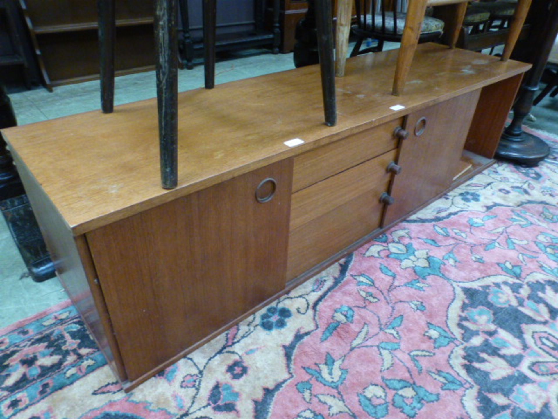 A teak sideboard having three drawers fl