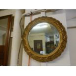 A circular ornate gilt framed bevel glas