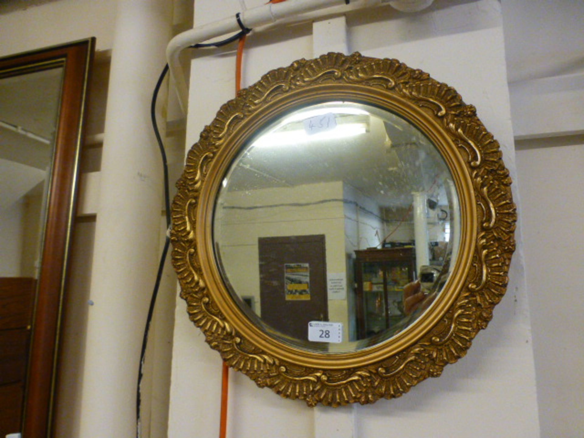 A circular ornate gilt framed bevel glas