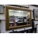 An ornate gilt framed rectangular bevel