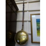 A brass and copper bed warming pan