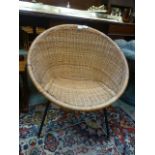 A mid-20th century wicker chair on black