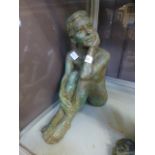 A stoneware clay sculpture of a seated n
