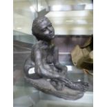 A bronze resin sculpture of a seated nud