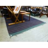 A modern flat woven rug in blue and gree