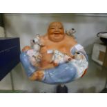 A ceramic model of a Buddha with childre