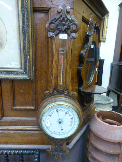 An early 20th century carved oak banjo b