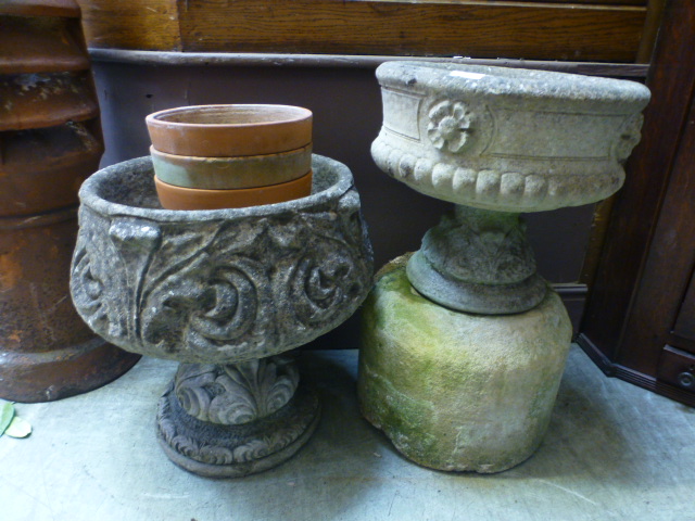 Two composite stone garden urns along wi