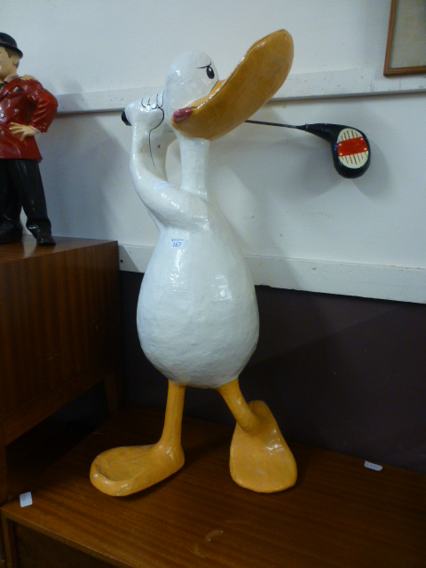 A papier mache model of a duck playing g