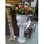 A white ceramic jardiniere stand with pl