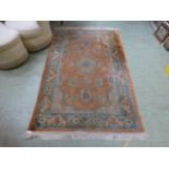 A handwoven Persian style rug, the peach