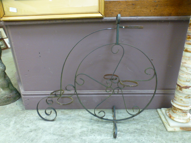 A wrought metal plant pot holder in the