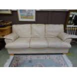 A cream leather three seater sofa