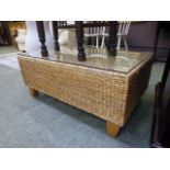 A wicker occasional table with glass top