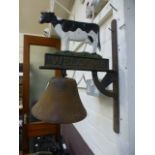 A cast metal wall hanging bell with cow