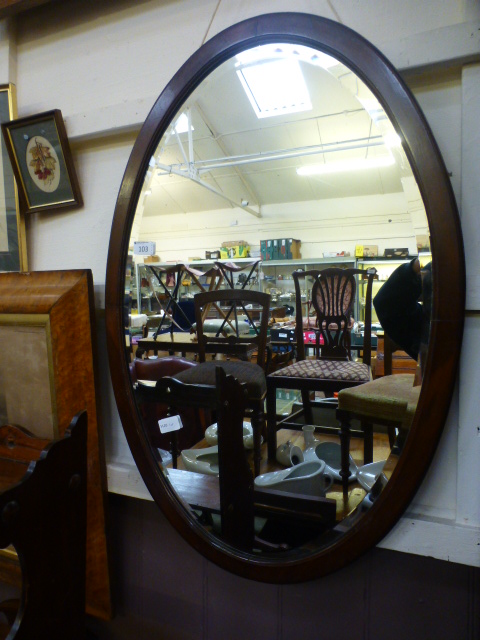 A mahogany oval bevel glass mirror