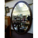 A mahogany oval bevel glass mirror