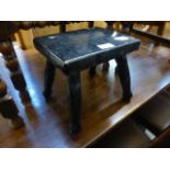 A small black painted milking stool