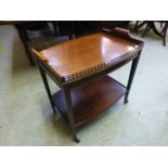 A reproduction mahogany two tier tea tro