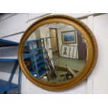 An ornate gilt framed oval bevelled glas