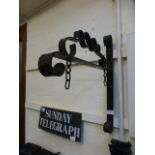 A wrought iron wall mounted sign hanging