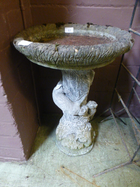 A composite stone bird bath with squirre