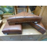 A tan leather foot stool along with a pa