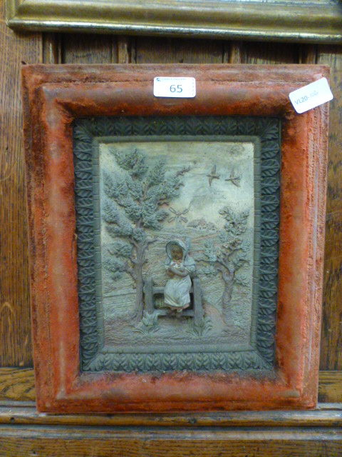 A felt framed ceramic relief panel of a