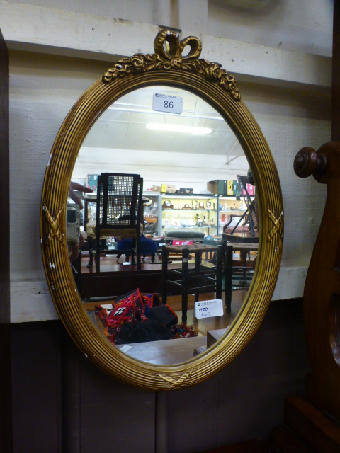 An ornate gilt framed oval mirror