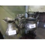 Two pewter cream jugs together with a pe