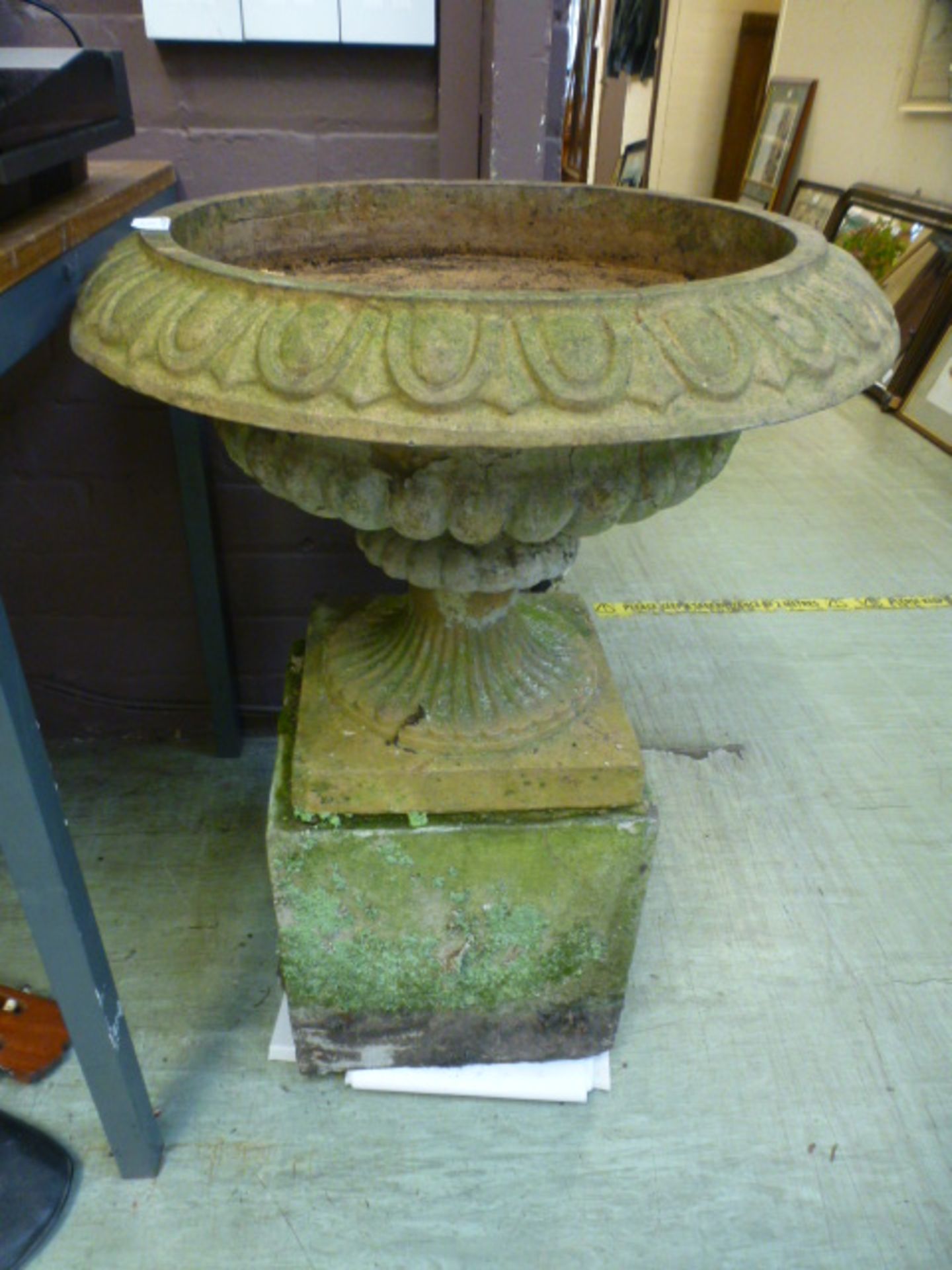 A composite stone planter on plinth