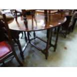 A reproduction oak drop leaf table