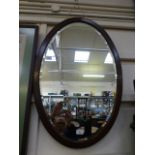 A mahogany oval bevel glass mirror