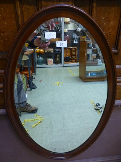 An early 20th century mahogany oval beve