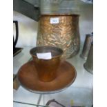 A hammered copper planter with camel des