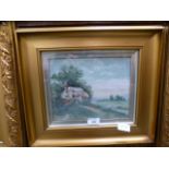 A framed and glazed oil of cottage scene